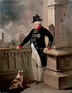 Full-length portrait of King George III, in black morning coat with red lapels and white breeches, facing left, looking out over London from a terrace at Windsor Castle.