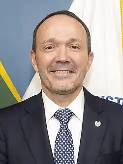 Gustavo Villatoro wearing a business suit and smiling facing the viewer