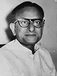 Mitra, a middle-aged Indian man in a white shirt and black spectacles, photographed showing his head and shoulders.