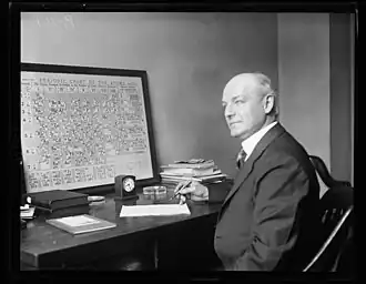 Henry D. Hubbard in front of his 1924 periodic table wallpaper