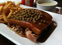 A Quebec-style "hot chicken", topped with green peas.