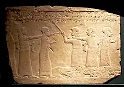 Humiliation of the Elamite King, forced to serve food at the court of Ashurbanipal. Inscription "...the kings of Elam, whom with the aid of Ashur and Ninlil my hands captured . . . they stood(?), and their own hands prepared their royal meal, and they brought it in before me".[9]