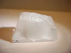 An ice cube resting on a white surface