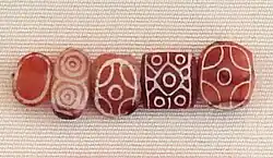 Indus carnelian beads with white design, etched in white with an acid, imported to Susa in 2600–1700 BC. Found in the tell of the Susa acropolis. Louvre Museum, reference Sb 17751.[40][41][42] These beads are identical with beads found in the Indus Civilization site of Dholavira.[43]