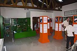 Several people stroll around a room full of exhibits.