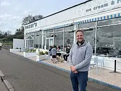 Man standing in front of restaurant.