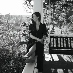 Joy Williams on the front porch of a house in the country