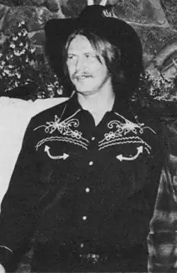 Man with distinctive mustache wearing Western attire
