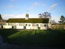 An array of kennels on flat grassy ground