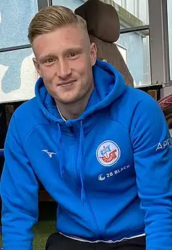 Kevin Schumacher wearing a blue jacket with F.C. Hansa logo on it