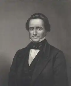 Green dressed in a jacket, seated facing the viewer