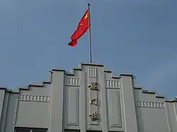 Picture of Longmen Building and Chinese Flag.