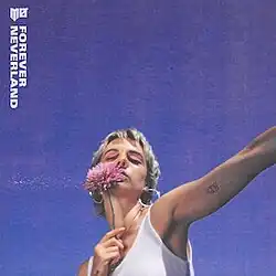 MØ holding a pink flower against a purple sky background.