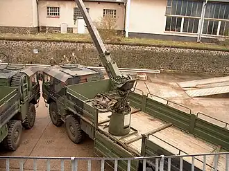 MAN Category I Type 464 LKW 10t mil gl MW Pritsche Kran 10,000 kg 8×8 cargo truck of the German Bundeswehr fitted with a self-recovery winch and body-mounted materials handling crane; the Atlas-Weyhausen 1-ton loading crane is deployed