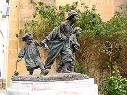 bronze sculpture of three street children running playfully