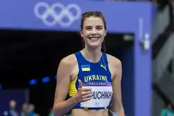 Photo of Yaroslava Mahuchikh in a blue athletics outfit holding up her right thumb
