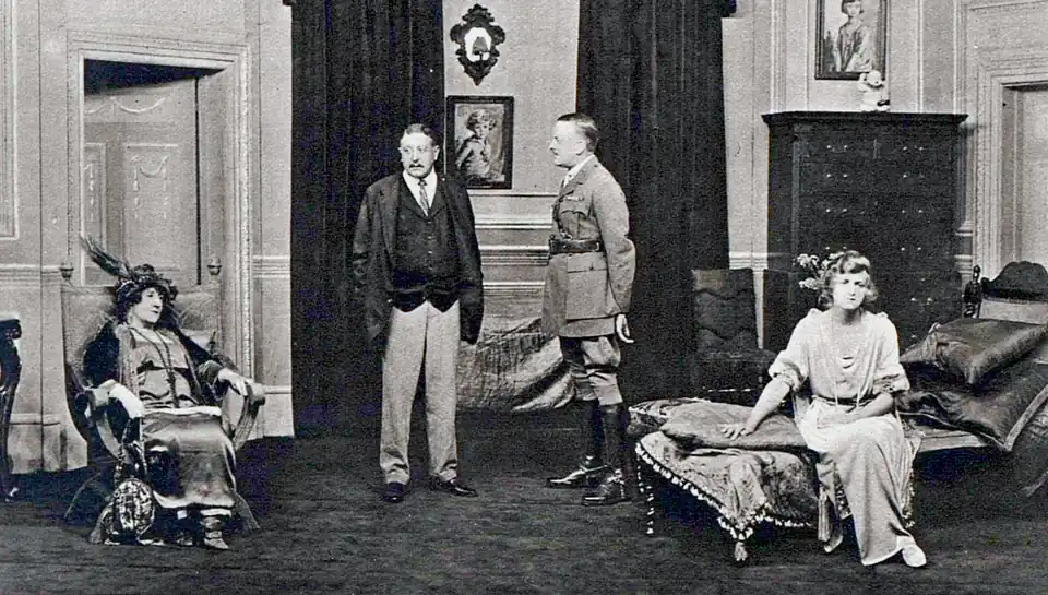 indoor scene with two white men (centre) one in civilian clothes and the other in army uniform, flanked by two seated white women