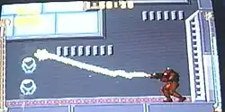 A video game screenshot of a person in a powered exoskeleton firing a beam.