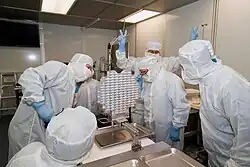 An investigator flashes V-for-victory signs upon the 2006 arrival of material gathered by the Stardust spacecraft at the Johnson Space Center in Texas.