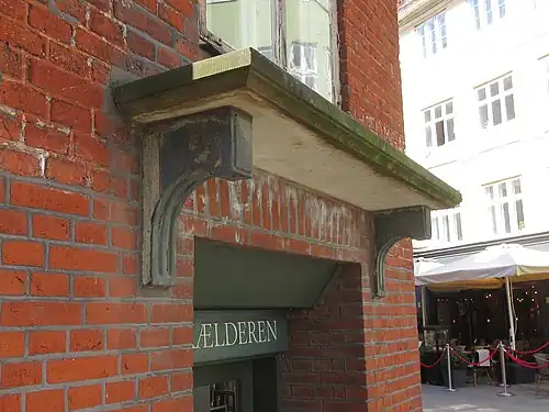 The hood mould above the basement entrance in the corner