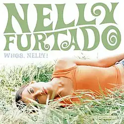 On a white background, Furtado lies on the grass on her side, looking at the camera. "Nelly Furtado" is written in 60s-inspired forest green capital letters, and "Whoa, Nelly!" in smaller, light-blue capital letters.