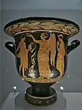 Nike, holding a phiale in her left hand, with her right hand crowns a young man (actor?) holding a female mask, bell krater, London, British Museum F163 (c. 400-380 BC).[126]