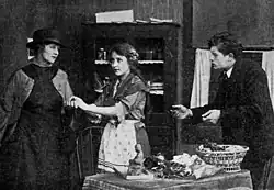 A blind girl stands between a woman and young man