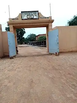 A gate for vehicles with a sign saying "OFFICE DE RADIODIFFUSION ET TELEVISION DU NIGER"
