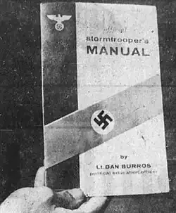 Black and white photo of the Official Stormtrooper Manual being held in someone's hand. It is emblazoned with a swastika across it and credited to Burros
