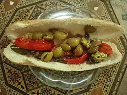 Sandwich filled with olives and sliced tomatoes