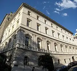 Angular view of a big building with three arched windows on the first floor and three arched doors on the ground floor.