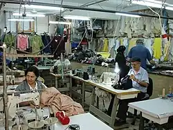 People at sewing machines in a small garment factory