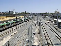 Six parallel tracks viewed from a bridge. The middle two tracks terminate and the outer two tracks on either side continue on.