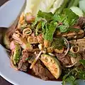 Phla nuea makhuea on is a Thai salad of medium rare beef and nearly raw sliced Thai eggplant