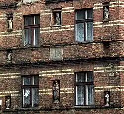 Facade of an old tenement house with figurines of Holy Mary