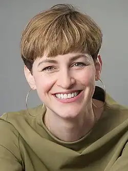Natalie Grams wearing golden earrings, with a short haircut