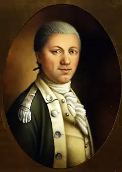 Bust-length portrait of caucasian male with gray hair, dark eyes wearing a 1700s military uniform - dark jacket with light-colored shoulder epaulettes; light-colored vest; band-collared, ruffled cravat shirt