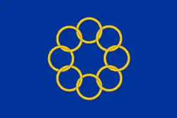 Flag featuring 8 golden interlocked rings on a blue background.