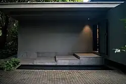 The access to the restaurant is through a small staircase next to a small pond.