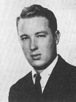Black and white head shot of Forbes wearing a suit
