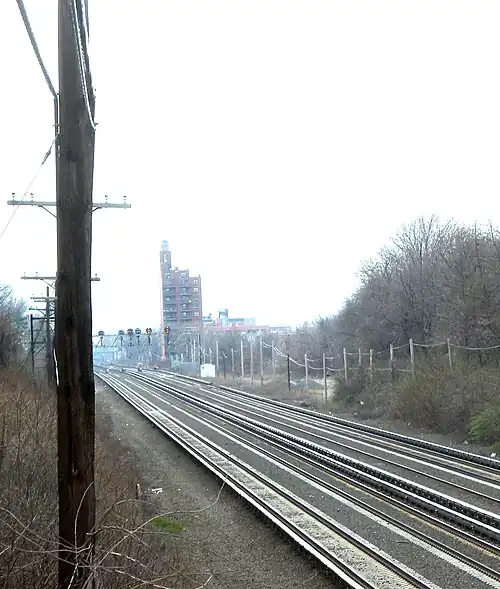Four parallel railroad tracks on the Long Island Rail Road's Main Line in Rego Park, New York. Two outer trackways can clearly be seen, and run parallel to the four railroad tracks.