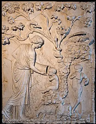 Young woman holds out a hollow horn to an infant's mouth