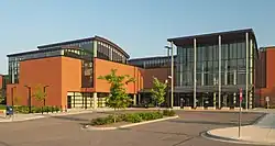 A modern glassy building with a wavy roof