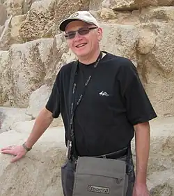 Rolf Theil Endresen, the first linguist to extensively document Nizaa. He is an older man with sunglasses and a baseball cap leaning on a rock