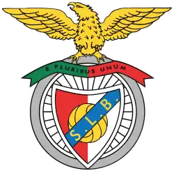 Looking to its right, a wingspread golden eagle stands atop a bicycle wheel's grey tire. Below, on the spoked wheel, a horizontal green and red strip reads "E PLURIBUS UNUM", and a diagonal blue strip with the golden initials "S. L. B." overlays a red and white shield with a golden football on its centre.