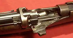 A Lee-Enfield Mk III rifle with the bolt pulled back. The bolt lugs lock into the receiver bridge and are rear-locking.[9]