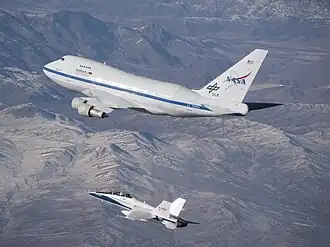 An F/A-18 mission support aircraft shadows SOFIA during a functional check flight.