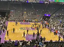 Several Kings players on the court with mostly empty stands