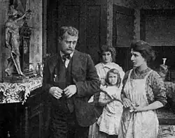 Black and white film still showing a family group