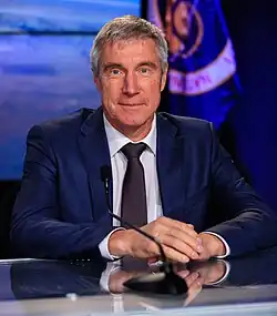 Krikalev posing in a blue suit at a desk